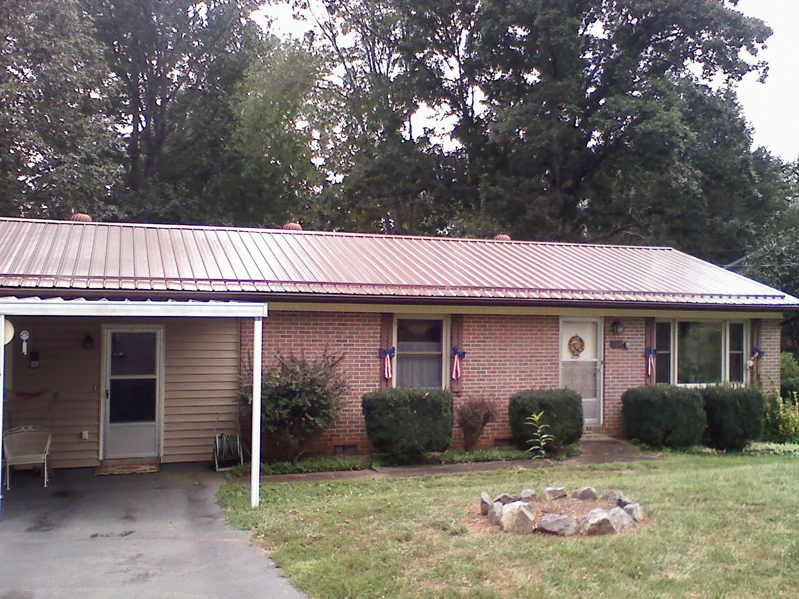 Bronze metal roof and carport on a brick ranch home — Roof Repair work by our crew in New Albany